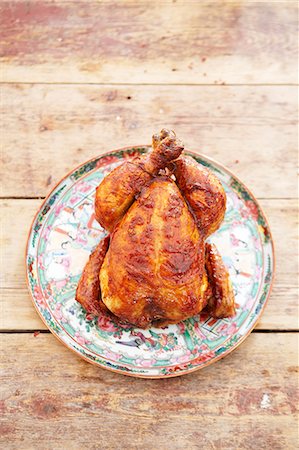 roasted (meat) - A whole roast chicken on a ceramic dish Stock Photo - Premium Royalty-Free, Code: 659-07027338