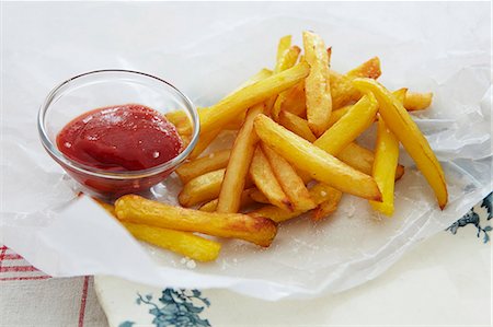 spud - Ketchup on French fries, close-up, elevated view Stock Photo - Premium Royalty-Free, Code: 659-07027412