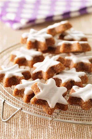 frosted - Star-shaped cinnamon biscuits on a cooling rack Stock Photo - Premium Royalty-Free, Code: 659-07027767