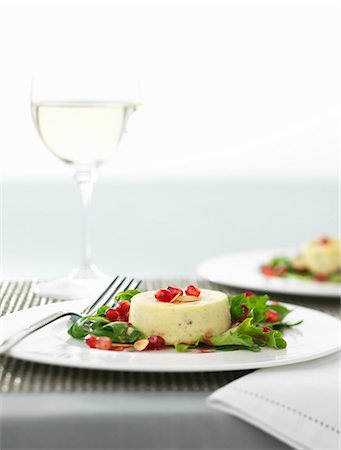 Individual Stilton tart with pomegranate seeds and rocket Stock Photo - Premium Royalty-Free, Code: 659-07027847