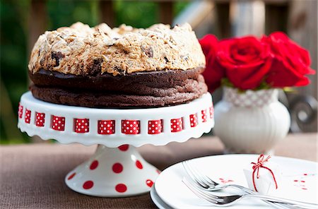 Chocolate Hazelnut Meringue Cake on a Cake Plate; Red Roses in a Vase Stock Photo - Premium Royalty-Free, Code: 659-07028030