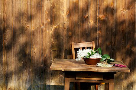 farmyard - Elderflowers in a bowl on a table outside a wooden cabin Foto de stock - Sin royalties Premium, Código: 659-07028640