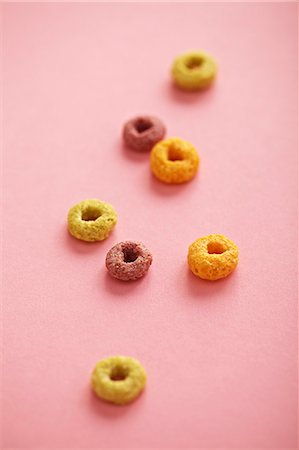 ring (shape) - Pieces of breakfast cereal on a pink surface Stock Photo - Premium Royalty-Free, Code: 659-07028771