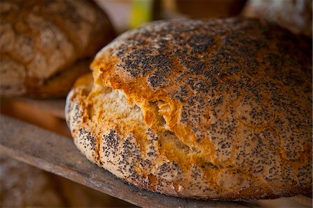 Freshly baked poppy seed bread on a wooden shelf Stock Photo - Premium Royalty-Free, Code: 659-07068795