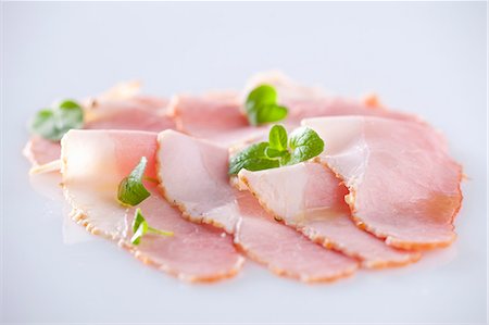 Slices of ham with oregano leaves Stock Photo - Premium Royalty-Free, Code: 659-07069160