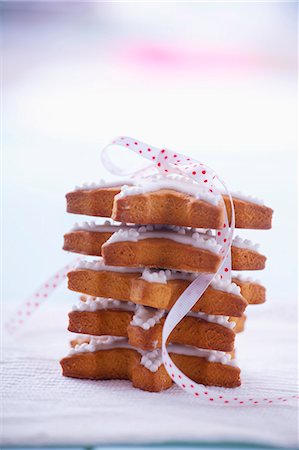 Pile of gingerbread stars garnished with icing and tied with ribbon Photographie de stock - Premium Libres de Droits, Code: 659-07069208