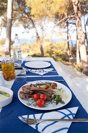 set - Grilled lamb chops with green asparagus, cherry tomatoes and roast potatoes on a table outdoors Photographie de stock - Premium Libres de Droits, Code: 659-07069577