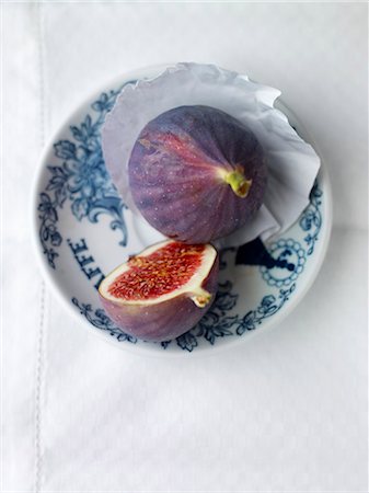 sopra - A whole fig and half a fig on a plate Fotografie stock - Premium Royalty-Free, Codice: 659-07069687