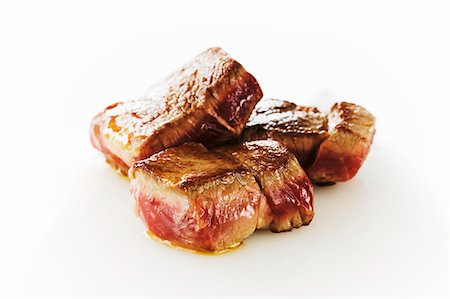 Seared Lamb Cubes on a White Background Stock Photo - Premium Royalty-Free, Code: 659-07597700