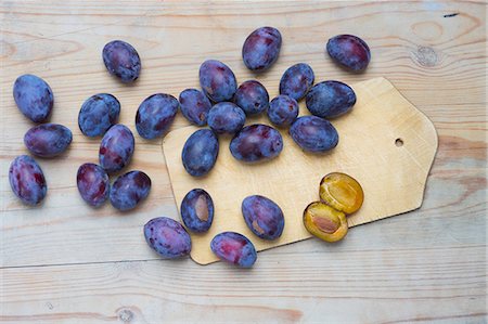 simsearch:659-06373112,k - Fresh plums on a chopping board and on a wooden surface Stock Photo - Premium Royalty-Free, Code: 659-07598348