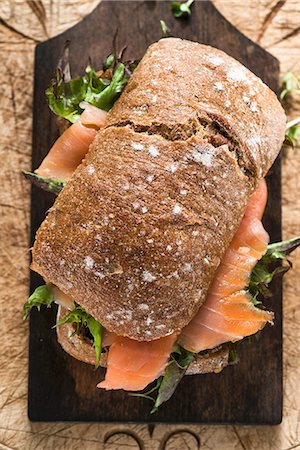 A smoked salmon and lettuce sandwich on a chopping board Stock Photo - Premium Royalty-Free, Code: 659-07598358