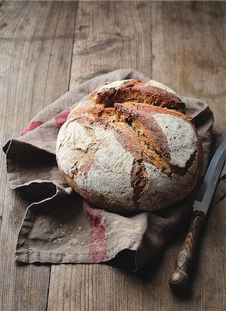 A loaf of rye bread on a dish towel Stock Photo - Premium Royalty-Free, Code: 659-07599085