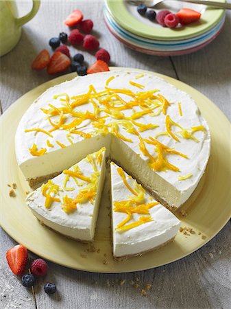 simsearch:659-06185283,k - Cheesecake with lemon zest, partly sliced Stock Photo - Premium Royalty-Free, Code: 659-07609671