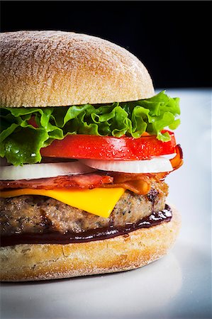 Cheeseburger with bacon and barbecue sauce (section) Stock Photo - Premium Royalty-Free, Code: 659-07609687