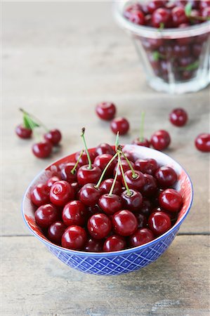 simsearch:659-07597339,k - Fresh cherries in a blue and white bowl on a wooden surface Stock Photo - Premium Royalty-Free, Code: 659-07609855
