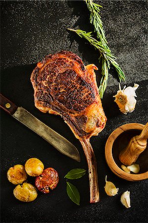 Tomahawk steak served with a baked potato Stock Photo - Premium Royalty-Free, Code: 659-07738660