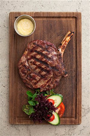 A grilled beef chop on a wooden board (seen from above) Stock Photo - Premium Royalty-Free, Code: 659-07739485
