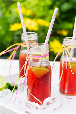 simsearch:659-06495307,k - Three small bottles of iced tea with lime, peppermint and ice cubes on a garden table Stock Photo - Premium Royalty-Free, Code: 659-07739834
