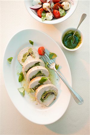 sopra - Turkey roulade with ham and a herb pesto served with a tomato and mozzarella salad Fotografie stock - Premium Royalty-Free, Codice: 659-07739917