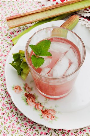 simsearch:659-06184015,k - A glass of rhubarb spritzer with ice cubes and pieces of rhubarb on an old, rose patterned plate Stock Photo - Premium Royalty-Free, Code: 659-07958322