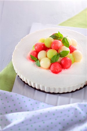 simsearch:659-06373404,k - A cream cheesecake decorated with colourful melon balls and peppermint leaves Stock Photo - Premium Royalty-Free, Code: 659-07958639
