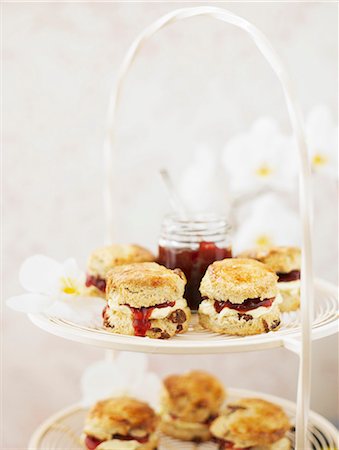 Scones with cream and strawberry jam on a white metal cake stand Stock Photo - Premium Royalty-Free, Code: 659-07958784
