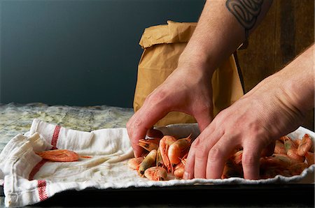 A chef filling a paper bag with cooked prawns Stock Photo - Premium Royalty-Free, Code: 659-07958797