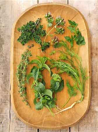 Fresh herbs on a wooden platter: thyme, lemon thyme, oregano, parsley, mint, dill Stock Photo - Premium Royalty-Free, Code: 659-07959606