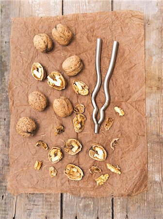 Walnuts, whole and cracked, with a nut cracker Stock Photo - Premium Royalty-Free, Code: 659-07959612