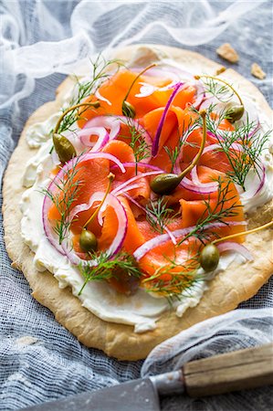 food - A blind-baked pizza base topped with cream cheese, smoked alpine salmon, dill, red onions and capers Stock Photo - Premium Royalty-Free, Code: 659-07959948