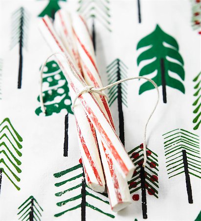 simsearch:659-07069631,k - Sticks of peppermint rock on a table with a cloth decorated with Christmas trees Stock Photo - Premium Royalty-Free, Code: 659-08146985