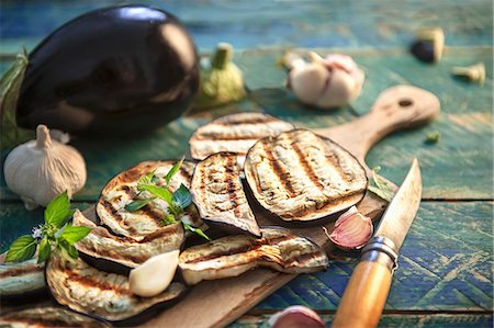 Grilled aubergine slices, garlic and peppermint on a rustic wooden table Stock Photo - Premium Royalty-Free, Code: 659-08146995