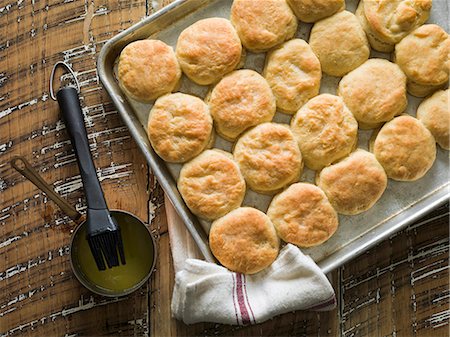 Buttermilk biscuits on a baking tray with melted butter and a baker's brush Foto de stock - Sin royalties Premium, Código: 659-08147032