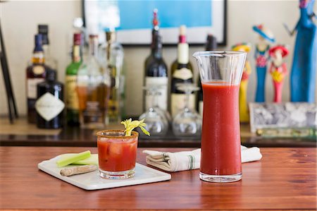 A classic Bloody Mary drink with celery on a table with a home bar in the background Stock Photo - Premium Royalty-Free, Code: 659-08147033