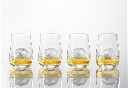 Four glasses of whiskey with ice cubes Stock Photo - Premium Royalty-Free, Code: 659-08147393