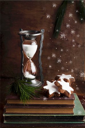 An arrangement featuring an antique sand timer and chocolate and nut Christmas biscuits Photographie de stock - Premium Libres de Droits, Code: 659-08147979