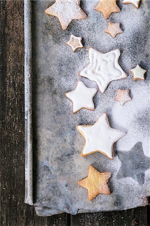 star (shape) - Glazed star-shaped Christmas biscuits with icing sugar on a baking tray Stock Photo - Premium Royalty-Free, Code: 659-08512841