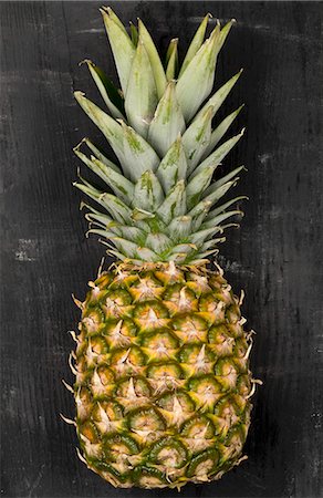 pineapple - A pineapple on a black surface Stock Photo - Premium Royalty-Free, Code: 659-08513153
