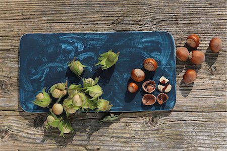 Green hazelnuts from a bush and ripe brown hazelnuts with one cracked Stock Photo - Premium Royalty-Free, Code: 659-08513225