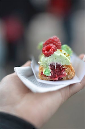 pistachio - A hand holding a raspberry and pistachio eclair Stock Photo - Premium Royalty-Free, Code: 659-08896124