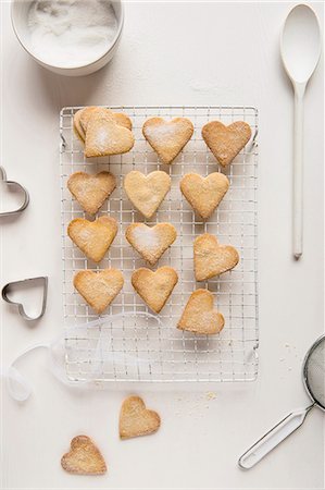 Heart-shaped butter biscuits coated in sugar on a cooling rack Photographie de stock - Premium Libres de Droits, Code: 659-08896452