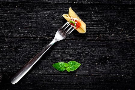 fork with noodles - Italian pasta with tomato and basil on fork On wooden board Stock Photo - Premium Royalty-Free, Code: 659-08896761