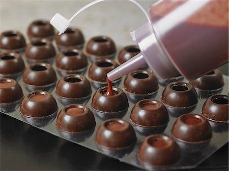 simsearch:841-06805239,k - Hollow chocolate balls being filled with fruit ganache from a bottle Stock Photo - Premium Royalty-Free, Code: 659-08904647
