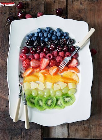 rainbow - Fruit salad arranged in rainbow stripes on a serving platter Foto de stock - Sin royalties Premium, Código: 659-08904829