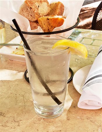 simsearch:659-06495307,k - A glass of ice water with a slice of lemon at a restaurant Stock Photo - Premium Royalty-Free, Code: 659-08906074