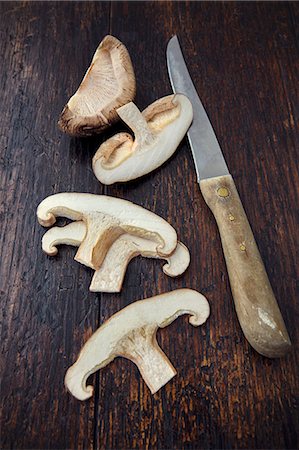 simsearch:659-03526248,k - A sliced shiitake mushroom with a knife on a wooden surface Stock Photo - Premium Royalty-Free, Code: 659-08906403