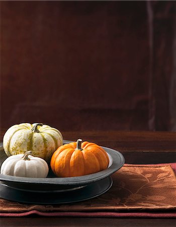 An arrangement of three decorative pumpkins in a grey metal dish Stock Photo - Premium Royalty-Free, Code: 659-08906593