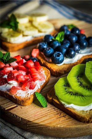 Healthy fruit open sandwiches on a wooden board Stock Photo - Premium Royalty-Free, Code: 659-08939913