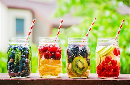 Four fruity drinks in screw-top jars on a garden table Photographie de stock - Premium Libres de Droits, Code: 659-08939959