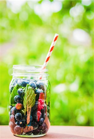 simsearch:659-06495307,k - Iced tea with blueberries in a screw-top jar with a straw on a garden table Stock Photo - Premium Royalty-Free, Code: 659-08939962